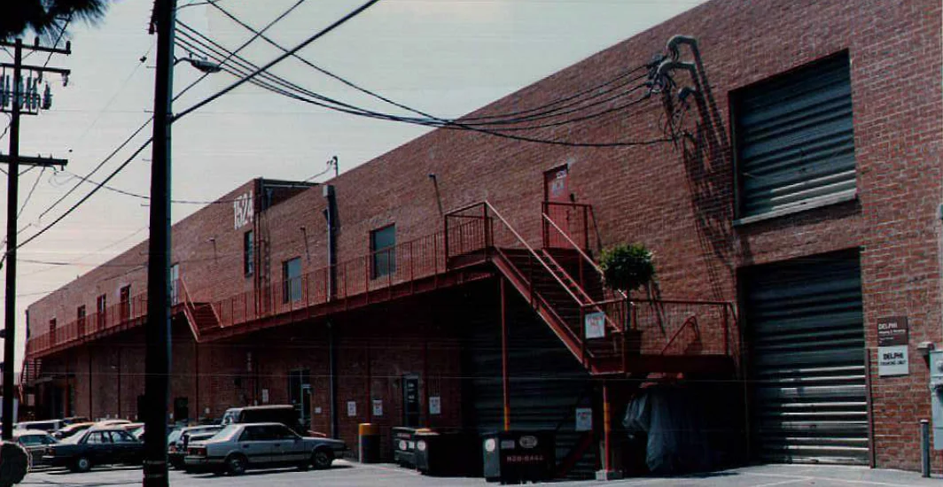 Archival view of the long brick elevation, exterior walkway and stairs before the later metal fascia
